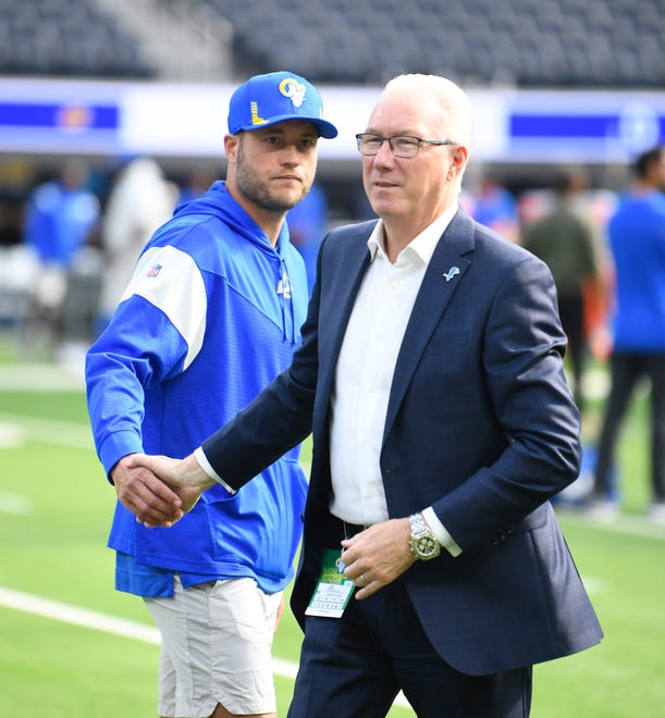 Rams quarterback Matthew Stafford shakes hands with Lions president and CEO Rod Wood after talking and laughing on the field with Wood before the game.