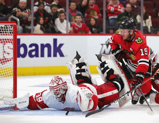 Red Wings goalie Alex Nedeljkovic makes a save against a shot by the Blackhawks' Jonathan Toews.