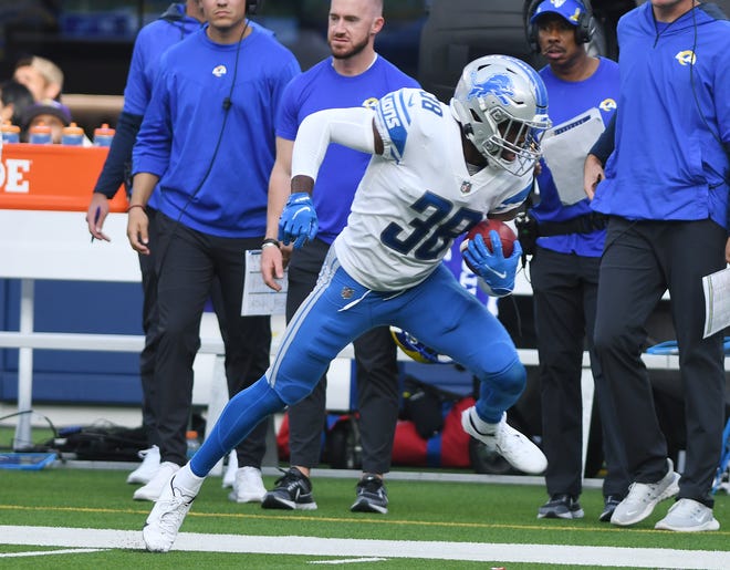 Lions' C.J. Moore takes the ball up the sidelines for a long first down on a fake punt in the third quarter.