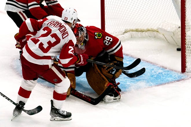 Red Wings left wing Lucas Raymond (23) scores against  Blackhawks goaltender Marc-Andre Fleury during the first period.