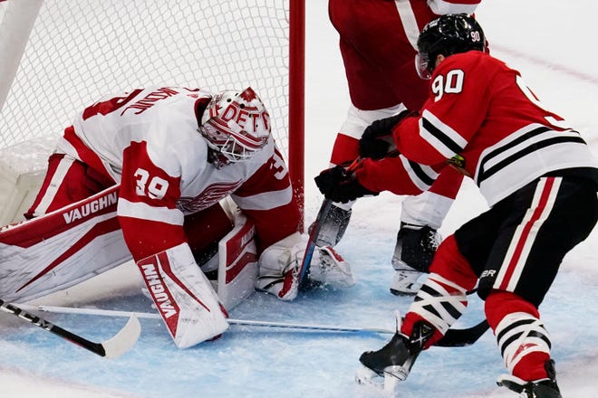 Red Wings goaltender Alex Nedeljkovic, left, makes a save on a shot by Blackhawks center Tyler Johnson during the third period.