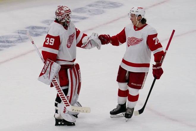 Red Wings goaltender Alex Nedeljkovic, left, celebrates with defenseman Troy Stecher after they defeated the Blackhawks, 6-3, in Chicago.
