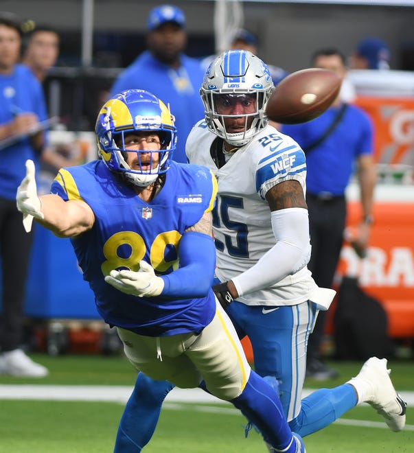 Rams’ Tyler Higbee stretches out in front of Lions’ Will Harris on a throw that eventually, after review, was called an incomplete pass in the third quarter.