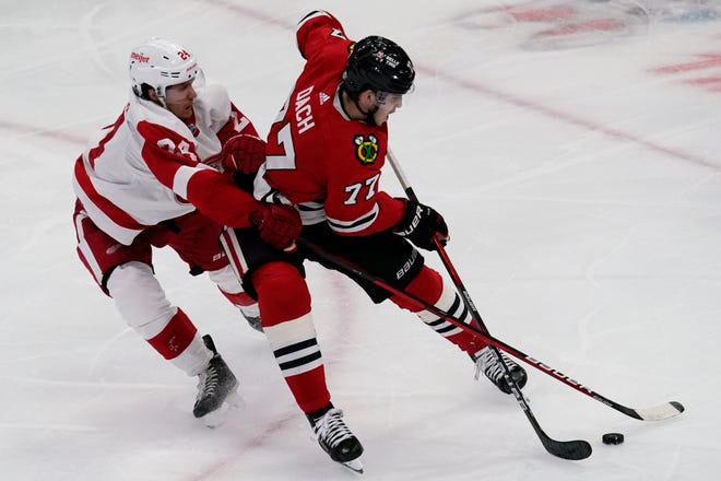 Red Wings center Pius Suter, left, and Blackhawks center Kirby Dach battle for the puck during the second period.