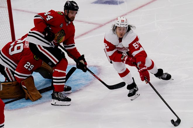 Red Wings left wing Tyler Bertuzzi, right, controls the puck against Blackhawks goaltender Marc-Andre Fleury, left, and defenseman Calvin de Haan during the second period.
