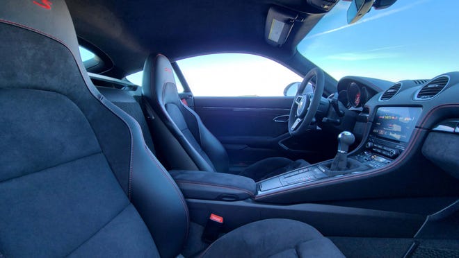 The interior of the 2021 Porsche Cayman GTS is all business: bucket seats, seat two, stick shift, chassis controls at the ready.