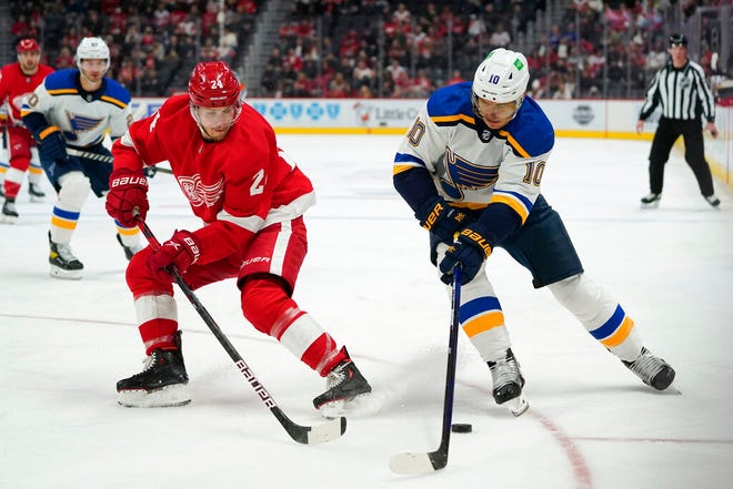 Detroit Red Wings center Pius Suter (24) and St. Louis Blues center Brayden Schenn (10) chase the puck in the first period of Wednesday's game at Little Caesars Arena.