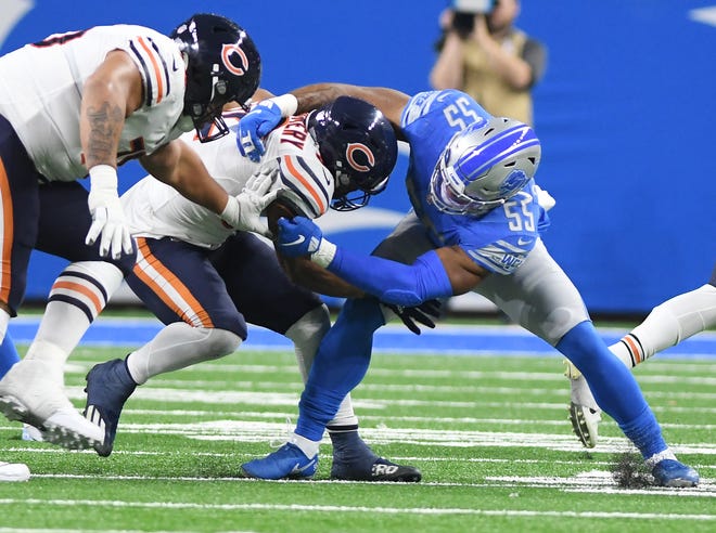 Bears running back David Montgomery is dragged down by Lions' Derrick Barnes in the fourth quarter.