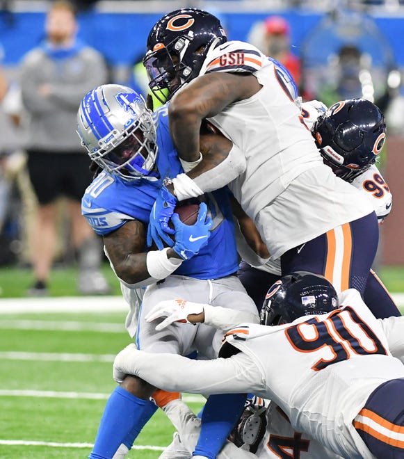 Lions running back Jamaal Williams (30) is wrapped up by BearsÕ Angelo Blackson (90), Bilal Nichols (98) and Trevis Gipson (99) in the fourth quarter.
