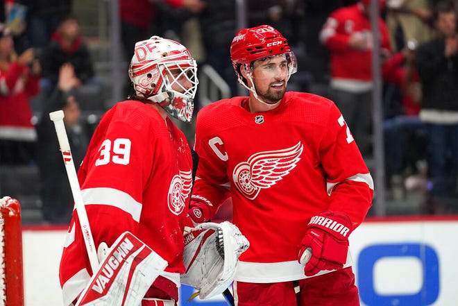 Detroit Red Wings goaltender Alex Nedeljkovic (39) and Dylan Larkin (71) celebrate after beating the St. Louis Blues 4-2 on Wednesday at Little Caesars Arena in Detroit.