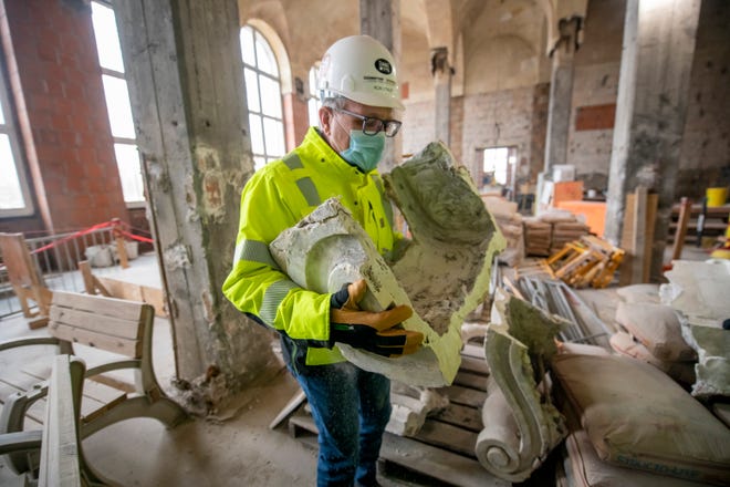Ron Staley, executive director of the Christman-Brinker joint venture, holds a damaged cartouche made from cast plaster that was removed from the walls of the main waiting area as construction continues at the Michigan Central Station, owned by Ford, in Detroit, January 11, 2022.
