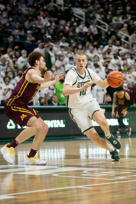 Michigan State forward Joey Hauser drives the ball around Minnesota forward Jamison Battle during the second half.