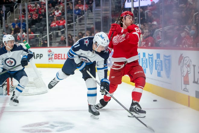 Winnipeg center Cole Perfetti and Detroit left wing Tyler Bertuzzi battle for the puck during the first period.
