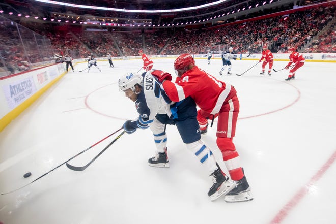 Winnipeg left wing CJ Suess and Detroit defenseman Marc Staal battle for the puck during the second period.