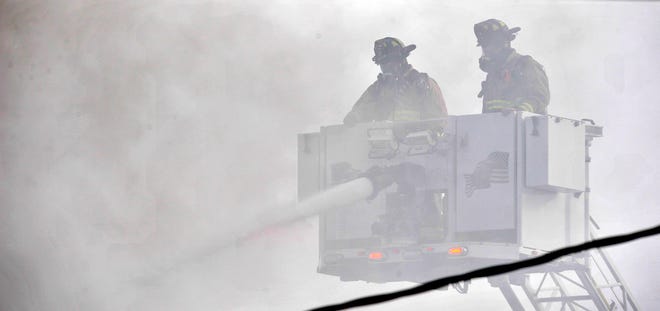 Firefighters battle the blaze from above as they work through the smoke on Friday, Jan. 14, 2022.