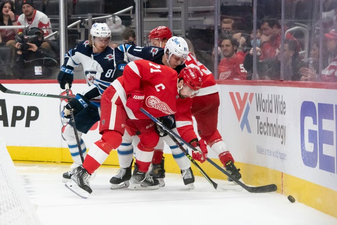 Detroit center Dylan Larkin battles for the puck with Winnipeg left wing Kyle Connor, left, and center Cole Perfetti during the second period.