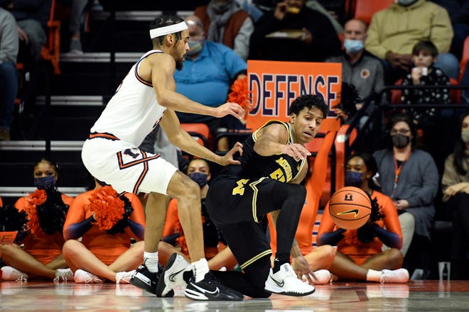 Michigan's Eli Brooks (55) stumbles as Illinois' Jacob Grandison defends during the first half.