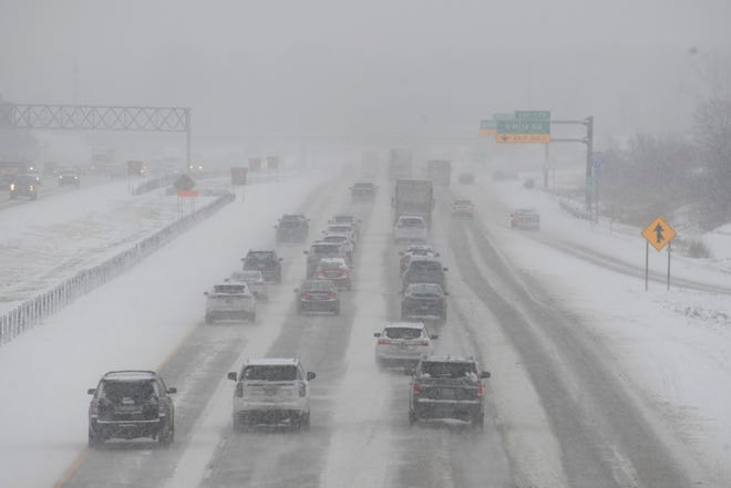 Cars make their way down a snow covered I-275 freeway near 7 Mile Road in Livonia, January 24, 2022.