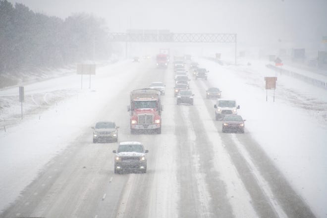 Cars make their way along the snow-covered I-275 freeway near 7 Mile Road in Livonia, Monday afternoon. The steady snow fall made fore a a slippery commute.