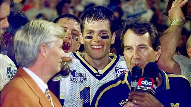 Michigan quarterback Tom Brady is all smiles while head coach Lloyd Carr is interviewed. Brady threw for a college-career-high 369 yards and four touchdowns while leading the Wolverines to a thrilling 35-34 overtime victory over Alabama in the Orange Bowl on Jan. 1, 2000. It was Brady's final game for the Wolverines. He was selected 199th overall in NFL draft.