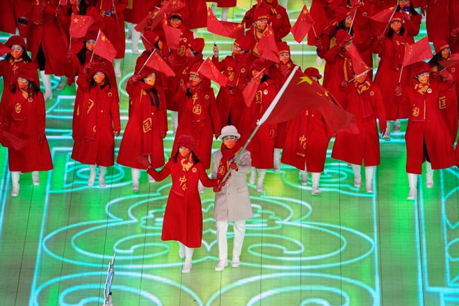 Gao Tingyu and Zhao Dan, of China, lead their team in during the opening ceremony of the 2022 Winter Olympics.
