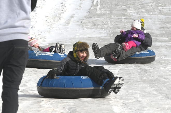 Children enjoy riding their inner tubes down a snow hill during Winter Blast in Royal Oak on Saturday, February 19, 2021.