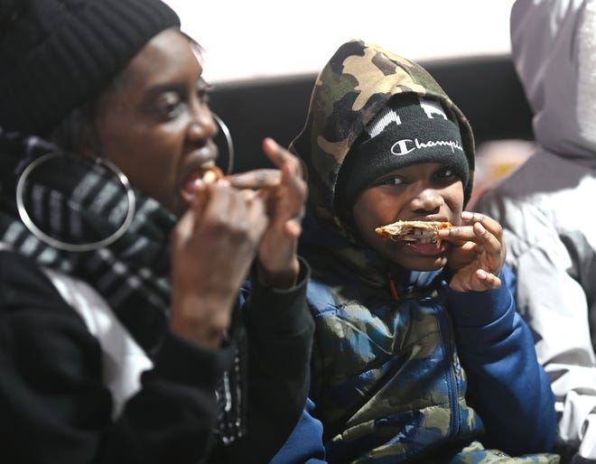 Shante Williams (left), of Taylor, enjoys a basket of bbq chicken with her son Cameron during Winter Blast in Royal Oak on Saturday, February 19, 2021.