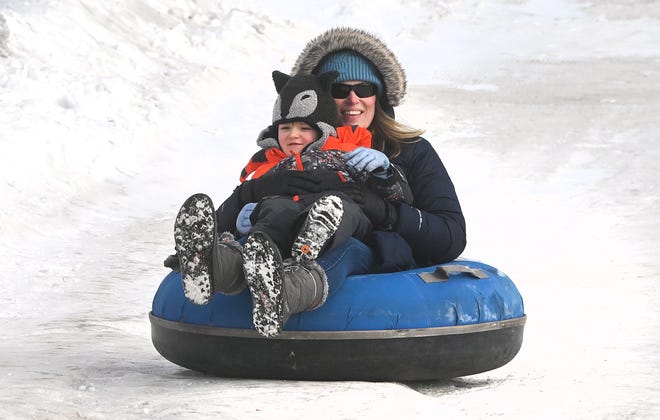 Asia Viers holds on to her son Camden, 4, as they inner tube down a snow hill during Winter Blast in Royal Oak on Saturday, February 19, 2021.