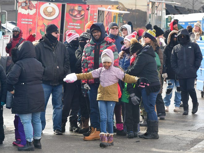 People wait in the cold weather to ride the zip line during Winter Blast in Royal Oak on Saturday, February 19, 2021.