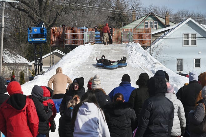 A large crowd watch children inner tube down a snow hill during Winter Blast in Royal Oak on Saturday, February 19, 2021.