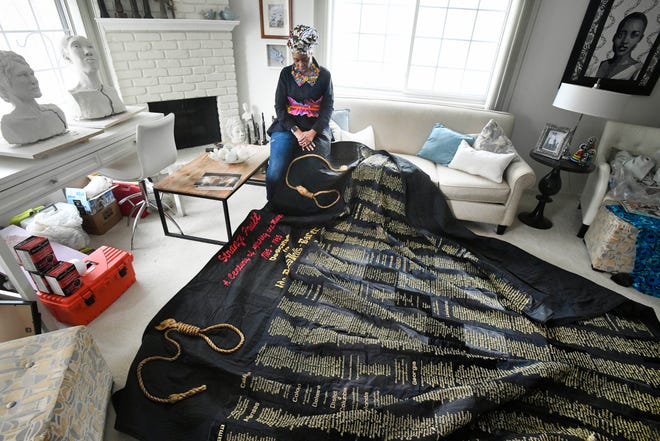 Artist April Anue Shipp after spreading out the 12 pound, 10' by 10.5' quilt "Strange Fruit," named after a song sung by the late Billie Holiday, with the embroidered names of 5,000 African American men, women, and children lynched in the United States. 
Artist April Anue Shipp at her home, studio in Rochester Hills, Michigan on March 1, 2022.