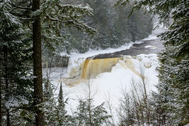 Snow falls on Upper Tahquamenon Falls near Paradise in Michigan's Upper Peninsula, Wednesday, March 2, 2022.