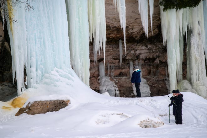Visitors take in the ice formations on Grand Island, in Lake Superior, near Munising, MI., Thursday, March 3, 2022.