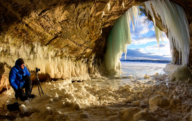 Photographer Ian Plant, Victoria, Minnesota, waits for just the right moment inside a cave on the east side of Grand Island, in Munising, Thursday, March 3, 2022.