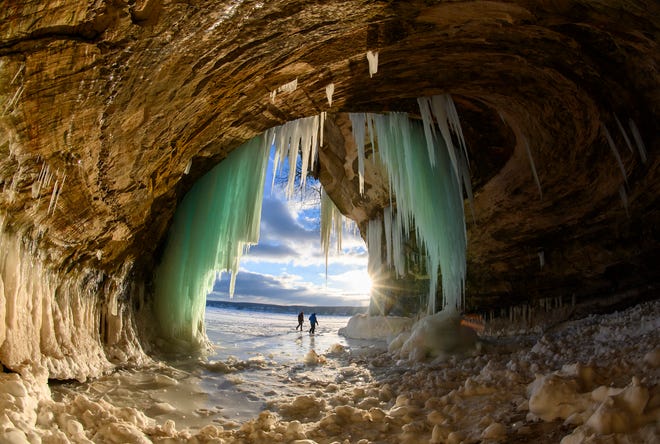 Scott Kusmirek and Ian Plant exit an ice cave on Grand Island, in Lake Superior, near Munising, MI., Thursday, March 3, 2022.
