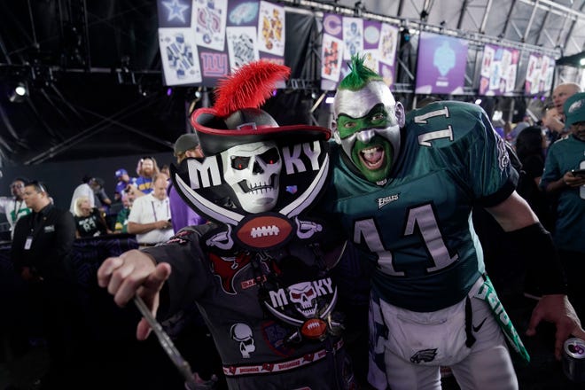 Fans wear costumes with the Philadelphia Eagles, right, and Tampa Bay Buccaneers colors during the first round of the NFL football draft Thursday, April 28, 2022.