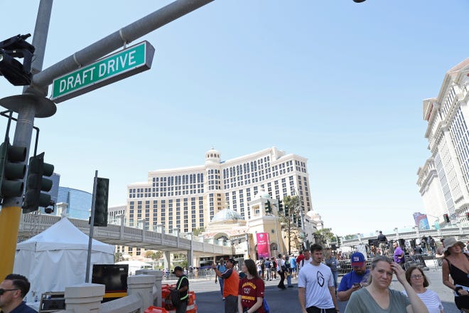Fans walk underneath a Draft Drive ceremonial street sign on Thursday, April 28, 2022, in Las Vegas.