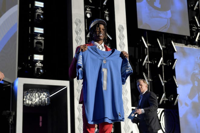 Jameson Williams poses onstage after being selected 12th by the Detroit Lions during round one of the 2022 NFL Draft.