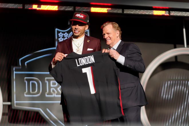 Southern California wide receiver Drake London, left, and Roger Goodell, Commissioner of the NFL, hold a team jersey after Drake London was chosen by the Atlanta Falcons with the 8th pick at the 2022 NFL Draft.