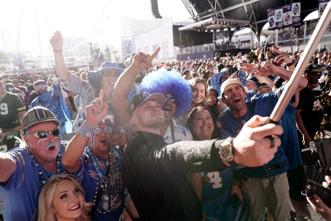 Michigan defensive end Aidan Hutchinson takes photos with fans after being selected by the Detroit Lions as the second pick in the NFL football draft.
