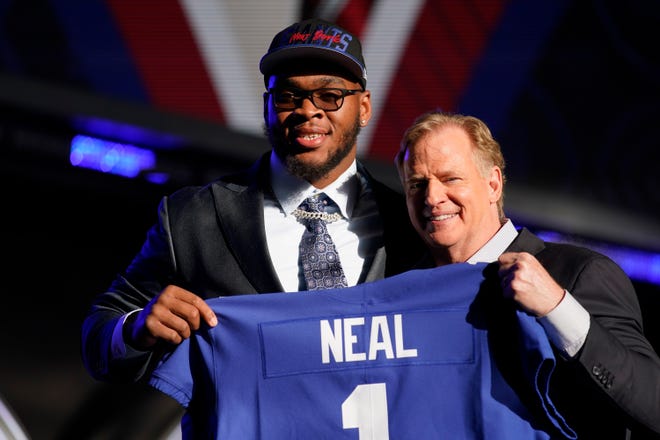Alabama offensive tackle Evan Neal stands with NFL Commissioner Roger Goodell after being picked by the New York Giants with the seventh pick of the NFL football draft.