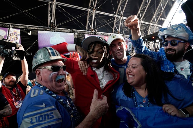 Alabama wide receiver Jameson Williams, in red, celebrates with fans after being chosen by the Detroit Lions with the 12th pick of the NFL football draft.