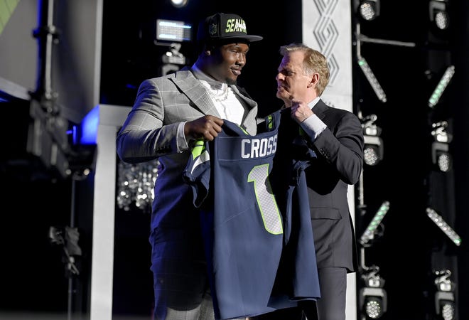 Charles Cross poses with NFL Commissioner Roger Goodell onstage after being selected ninth by the Seattle Seahawks during round one of the 2022 NFL Draft.