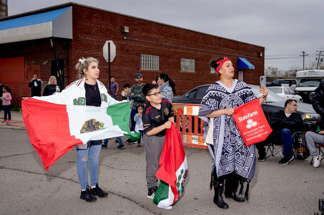 From left, Ana Flores, 19, Chris Coronado, 10, and Ana Coronado, all of Detroit, watch during the 57th annual Cinco de Mayo Parade in Detroit on May 1, 2022.
