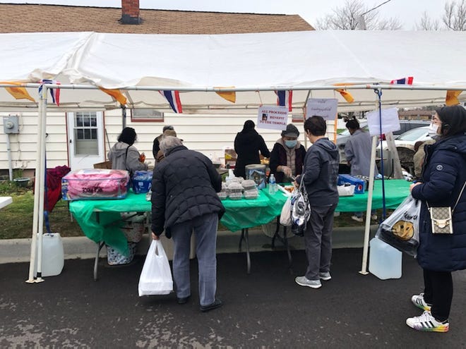 Vendors sell hot food and other items at the Thai Market at the Midwest Buddhist Meditation Center in Warren.