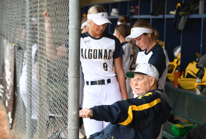 Algonac' Sierra Vosler, 16 and Brianna Thomason, 18 listen as softball coach Len Perkins works with his players during the 1-0 victory over Macomb Dakota in Macomb, Michigan on May 5, 2022.