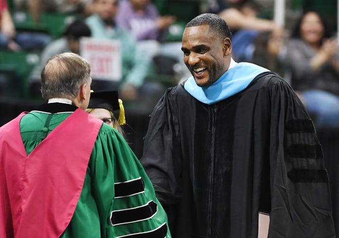 NBA and MSU basketball star Steve Smith shakes hands with Michigan State University President Samuel Stanley Jr., M.D. during the Michigan State University commencement ceremony at the Breslin Center in E. Lansing, Michigan on May 6, 2022.
