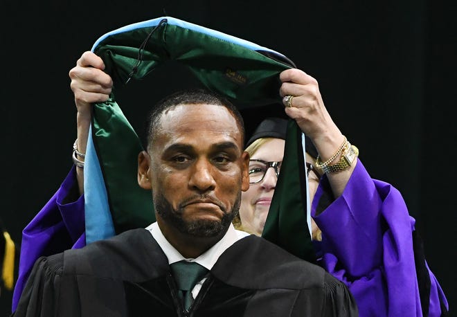 NBA and MSU basketball star Steve Smith has a sash placed over his head by Michigan State University Provost and Executive Vice President for Academic Affairs Teresa Woodruff, Ph.D. during an honorary degree ceremony at the MSU commencement at the Breslin Center in E. Lansing, Michigan on May 6, 2022.