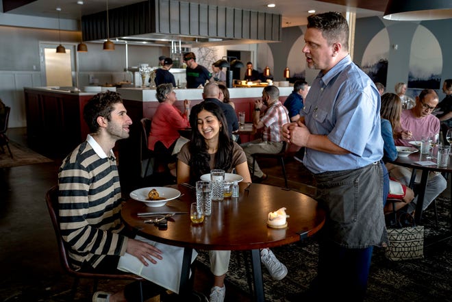 From left, Mohammad Turfah of Dearborn Heights and Nadia Hakim of Franklin listen to server Daniel Zalewski at Freya in Detroit on May 7, 2022.