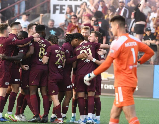 DCFC gather around Maxi Rodriguez after scoring on a penalty kick on Louisville goalie Kyle Morton in the first half.